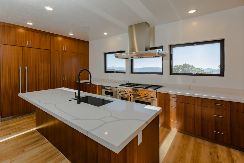 Large minimalist galley vinyl floor and brown floor eat-in kitchen photo in Salt Lake City with an undermount sink, flat-panel cabinets, medium tone wood cabinets, quartz countertops, white backsplash, quartz backsplash, stainless steel appliances, two islands and white countertops