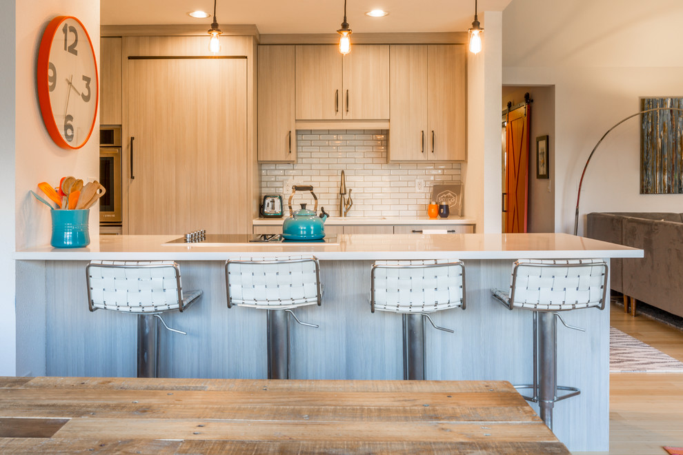 Photo of a small contemporary kitchen in Denver with a submerged sink, flat-panel cabinets, grey cabinets, engineered stone countertops, white splashback, ceramic splashback, integrated appliances, bamboo flooring, a breakfast bar and beige floors.