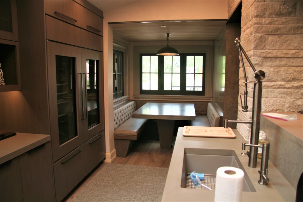 Open concept kitchen - mid-sized modern l-shaped light wood floor open concept kitchen idea in Denver with an undermount sink, flat-panel cabinets, an island, brown cabinets, zinc countertops, gray backsplash, porcelain backsplash and stainless steel appliances