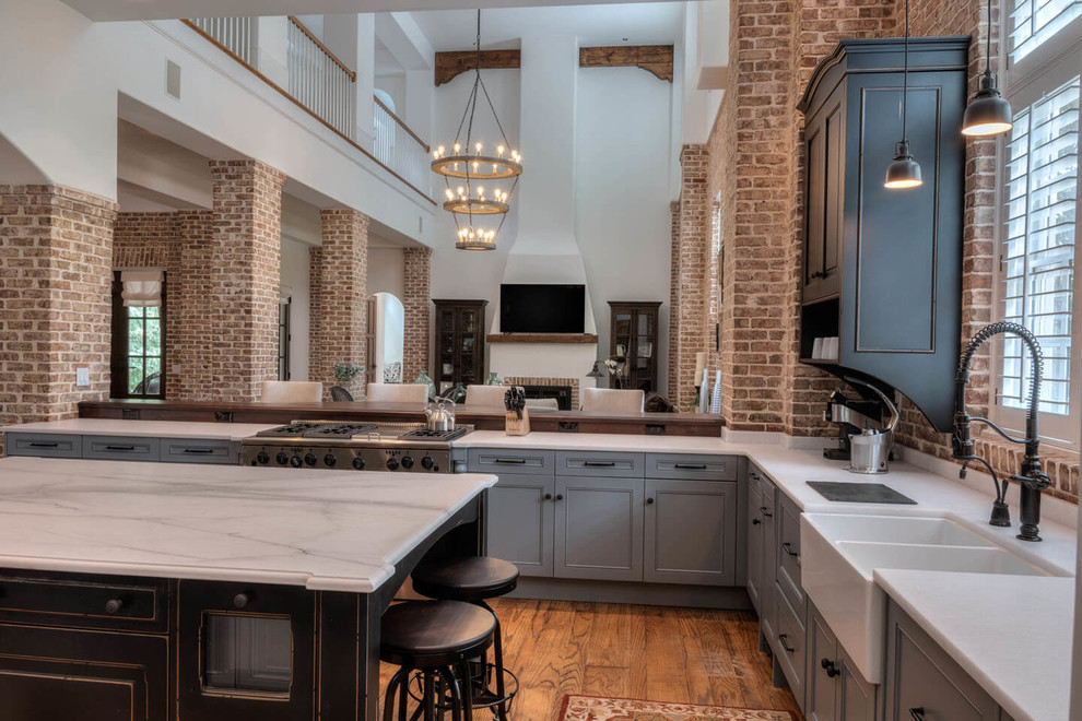 Inspiration for a large transitional u-shaped medium tone wood floor and brown floor eat-in kitchen remodel in Atlanta with a farmhouse sink, beaded inset cabinets, gray cabinets, marble countertops, brick backsplash, paneled appliances, an island and white countertops