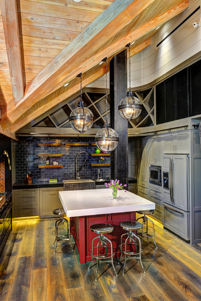 Foto på ett rustikt u-kök, med blått stänkskydd, stänkskydd i tunnelbanekakel och en köksö