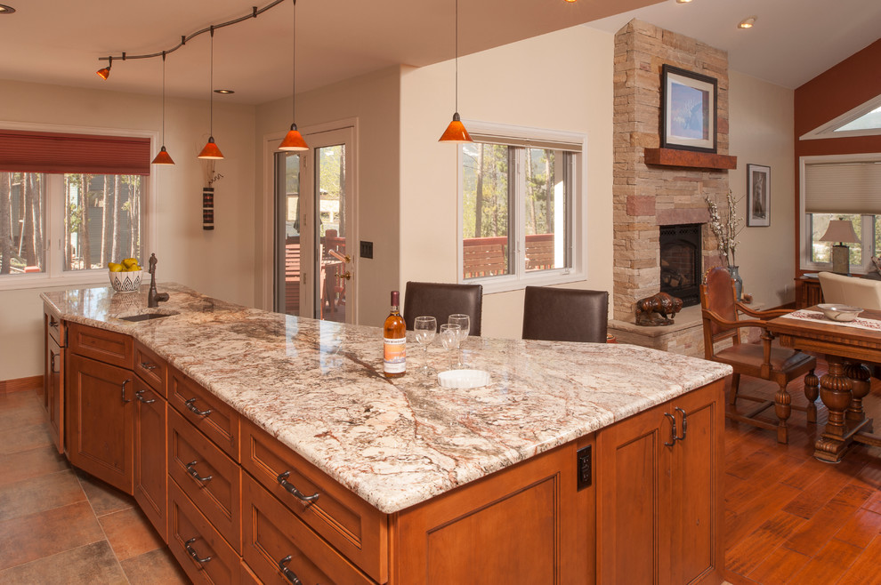 Mid-sized trendy l-shaped porcelain tile eat-in kitchen photo in Denver with an undermount sink, raised-panel cabinets, medium tone wood cabinets, granite countertops, white backsplash, subway tile backsplash, stainless steel appliances and an island
