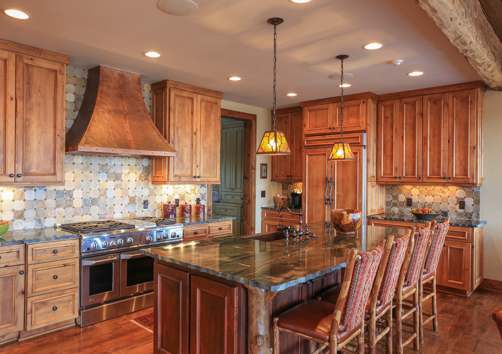 Mid-sized mountain style l-shaped medium tone wood floor eat-in kitchen photo in Charlotte with recessed-panel cabinets, medium tone wood cabinets, multicolored backsplash, stainless steel appliances, an island, a farmhouse sink, granite countertops and slate backsplash