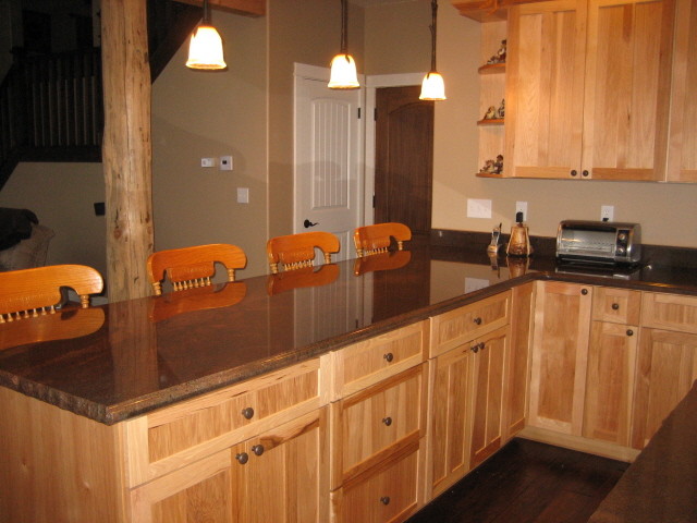 Mid-sized elegant u-shaped dark wood floor eat-in kitchen photo in Los Angeles with shaker cabinets, light wood cabinets, stainless steel appliances and an island