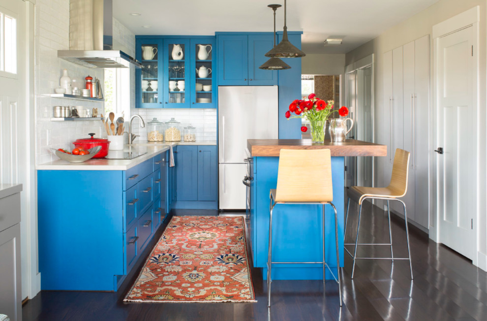 Eat-in kitchen - mid-sized transitional l-shaped dark wood floor and brown floor eat-in kitchen idea in Denver with shaker cabinets, blue cabinets, white backsplash, stainless steel appliances, an island, an undermount sink, solid surface countertops and subway tile backsplash