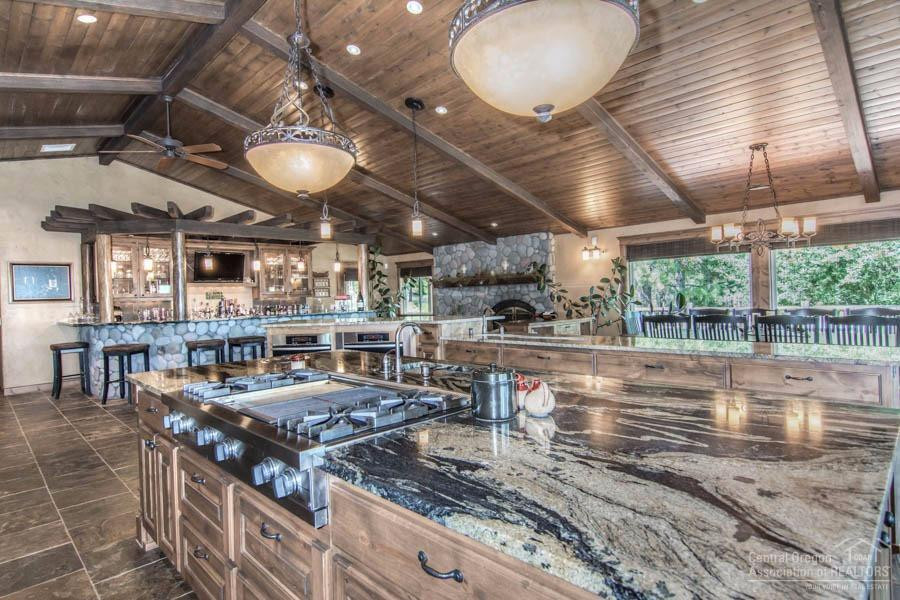 Inspiration for an expansive rustic l-shaped kitchen/diner in Other with raised-panel cabinets, medium wood cabinets, granite worktops, multi-coloured splashback, multiple islands, multicoloured worktops, slate splashback, stainless steel appliances, a submerged sink, slate flooring and multi-coloured floors.