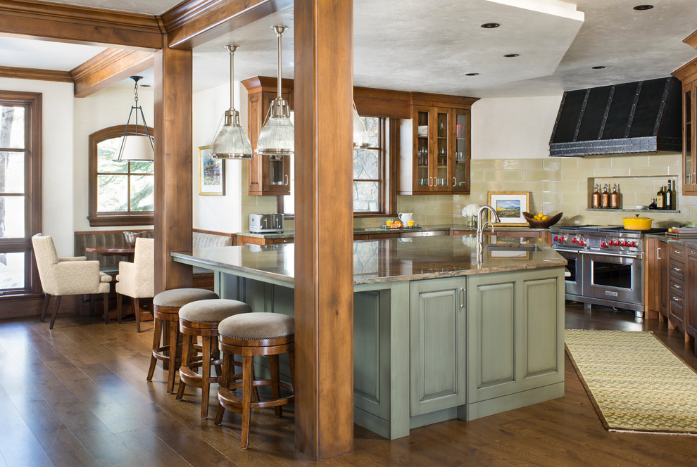 Exempel på ett stort rustikt kök, med en undermonterad diskho, luckor med glaspanel, skåp i mellenmörkt trä, granitbänkskiva, beige stänkskydd, stänkskydd i tunnelbanekakel, rostfria vitvaror, mörkt trägolv och en köksö