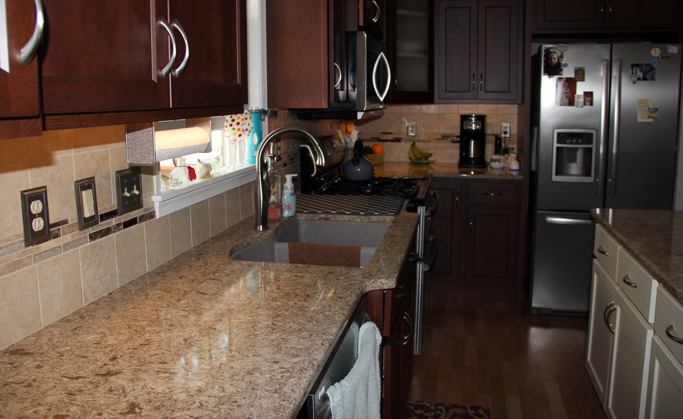Exempel på ett mellanstort modernt l-kök, med en köksö, skåp i mörkt trä, bänkskiva i kvarts, beige stänkskydd, stänkskydd i mosaik, rostfria vitvaror, en dubbel diskho och ljust trägolv