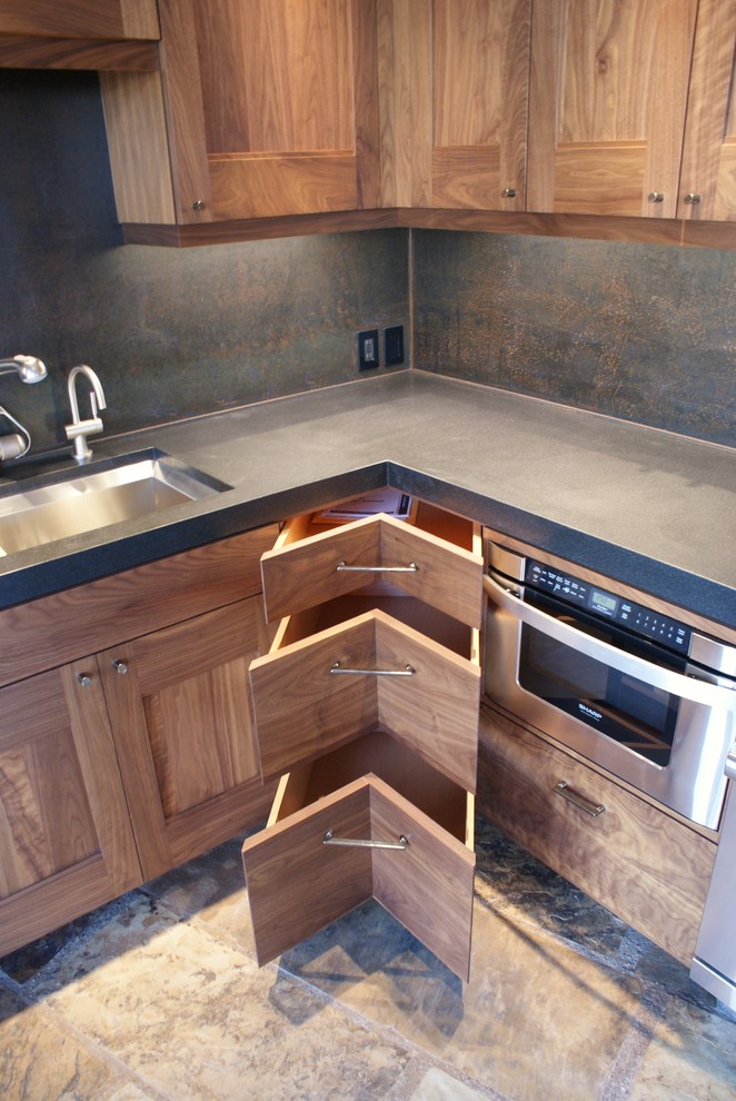 Amerikansk inredning av ett mellanstort kök, med svart stänkskydd, en dubbel diskho, skåp i shakerstil, skåp i mörkt trä, bänkskiva i betong, stänkskydd i sten, rostfria vitvaror och skiffergolv