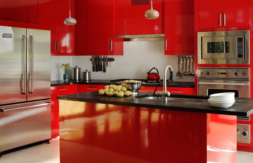 Пример оригинального дизайна: угловая кухня в современном стиле с врезной мойкой, плоскими фасадами, красными фасадами, техникой из нержавеющей стали и островом