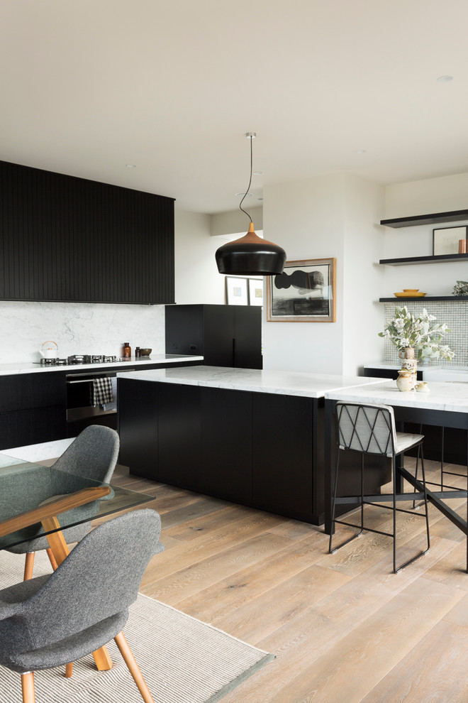Inspiration för ett stort minimalistiskt kök, med en rustik diskho, svarta skåp, marmorbänkskiva, flerfärgad stänkskydd, stänkskydd i mosaik, rostfria vitvaror, mellanmörkt trägolv och en köksö