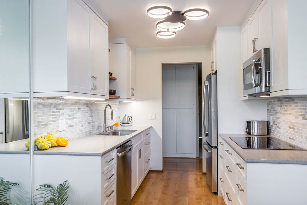 Foto på ett funkis grå kök och matrum, med en undermonterad diskho, skåp i shakerstil, vita skåp, bänkskiva i kvarts, flerfärgad stänkskydd, stänkskydd i marmor, rostfria vitvaror, mellanmörkt trägolv och brunt golv