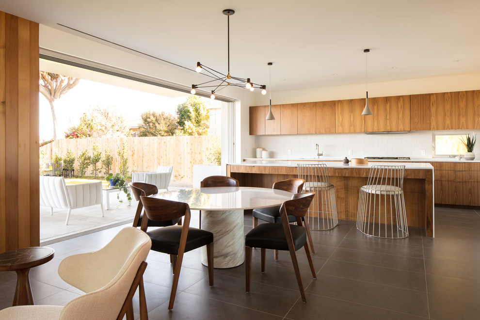 Medium sized modern single-wall kitchen/diner in Los Angeles with ceramic flooring, grey floors, flat-panel cabinets, medium wood cabinets, composite countertops, an island, white worktops, white splashback, stone tiled splashback and stainless steel appliances.