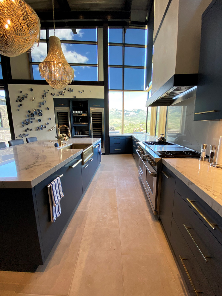 This is an example of a large contemporary u-shaped open plan kitchen in Other with a belfast sink, flat-panel cabinets, blue cabinets, marble worktops, white splashback, marble splashback, integrated appliances, limestone flooring, an island, grey floors, white worktops and a wood ceiling.