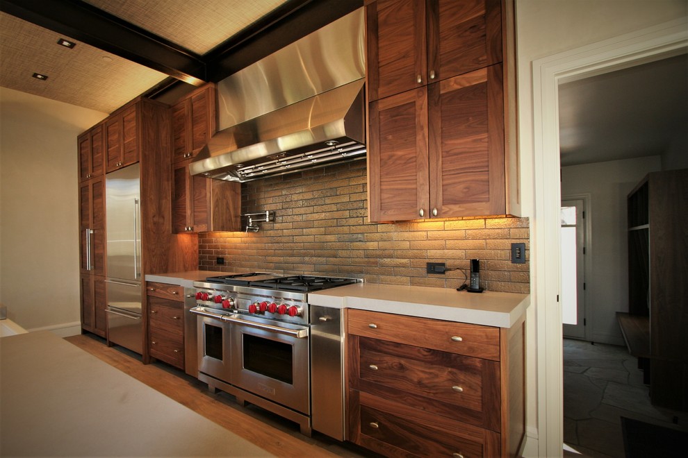 Exempel på ett mellanstort modernt kök, med en rustik diskho, skåp i shakerstil, skåp i mellenmörkt trä, bänkskiva i betong, rostfria vitvaror, ljust trägolv, en köksö, brunt golv, brunt stänkskydd och stänkskydd i stenkakel