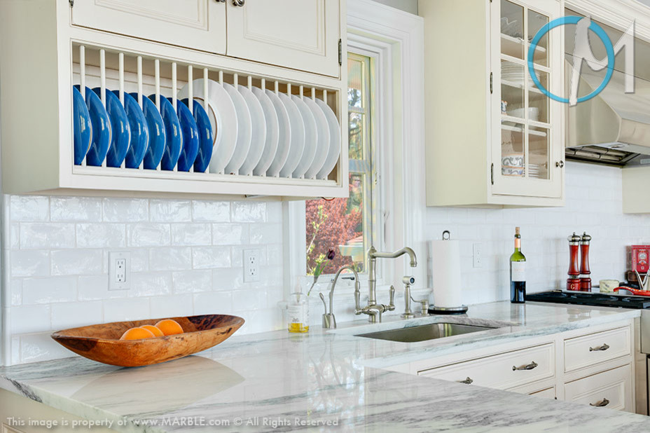 Example of a large beach style eat-in kitchen design in New York with marble countertops and an island