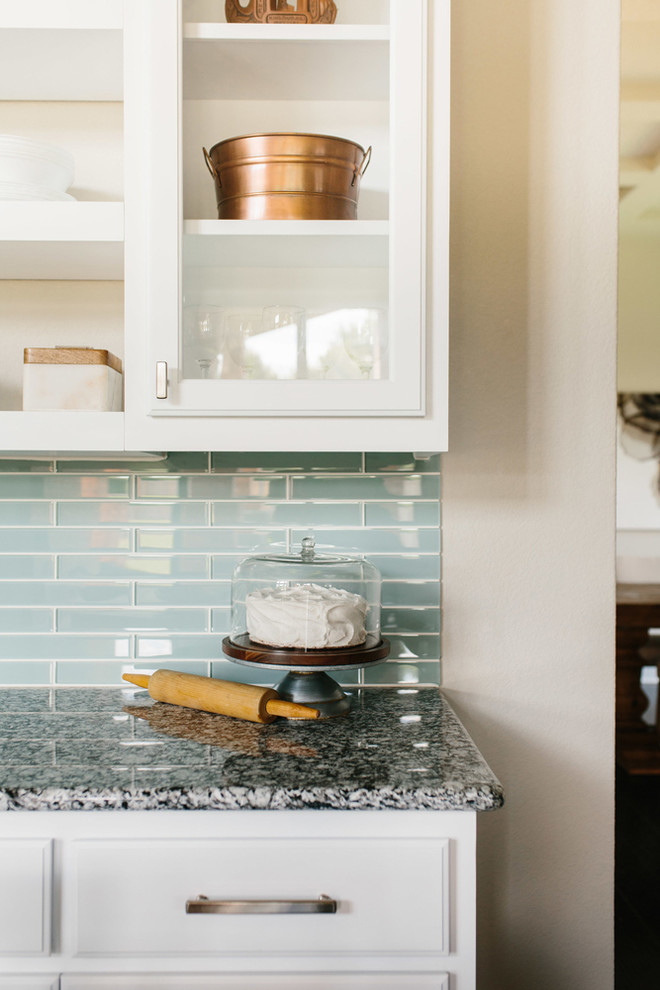 Foto på ett avskilt, mellanstort funkis grå u-kök, med en undermonterad diskho, skåp i shakerstil, vita skåp, granitbänkskiva, stänkskydd i cementkakel, rostfria vitvaror, mörkt trägolv och en köksö