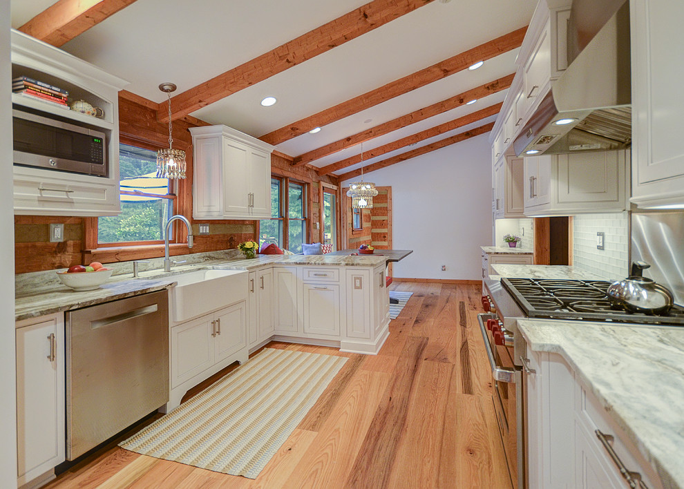 Photo of a medium sized country u-shaped kitchen/diner in DC Metro with a belfast sink, beaded cabinets, white cabinets and stainless steel appliances.