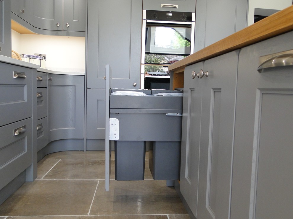 Medium sized contemporary l-shaped enclosed kitchen in Other with a submerged sink, shaker cabinets, grey cabinets, quartz worktops, stainless steel appliances, limestone flooring, an island, grey floors and white worktops.