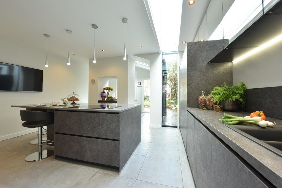 Photo of a medium sized contemporary galley kitchen/diner in Manchester with a submerged sink, flat-panel cabinets, grey cabinets, composite countertops, grey splashback, porcelain flooring, an island and grey floors.