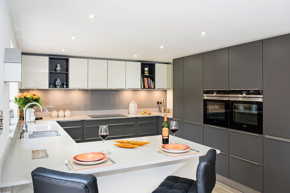 Свежая идея для дизайна: кухня-гостиная среднего размера в современном стиле с серыми фасадами, техникой из нержавеющей стали и полуостровом - отличное фото интерьера