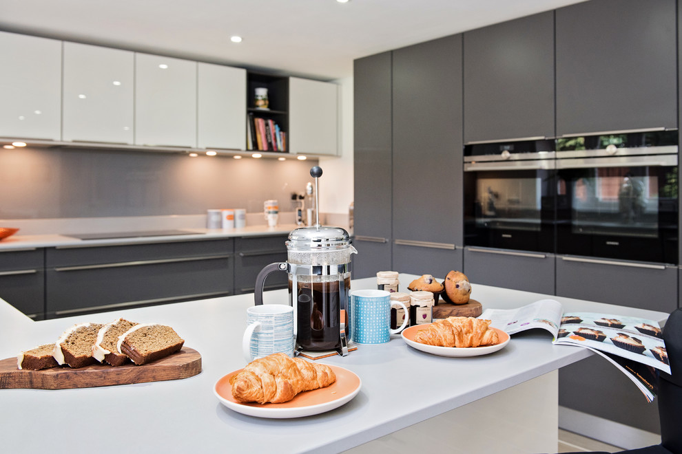 Foto de cocina contemporánea de tamaño medio abierta con puertas de armario grises, electrodomésticos de acero inoxidable y península
