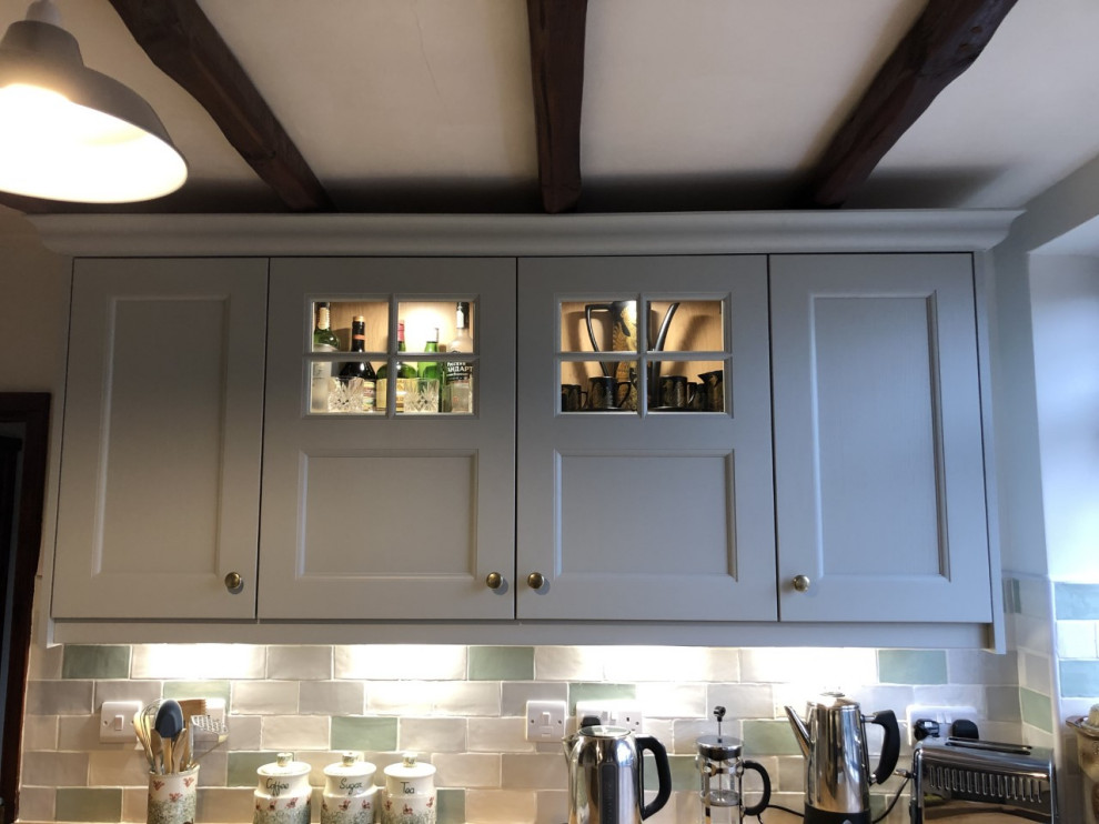 Klassisk inredning av ett mellanstort u-kök, med en rustik diskho, skåp i shakerstil, grå skåp, träbänkskiva, flerfärgad stänkskydd, stänkskydd i porslinskakel, svarta vitvaror och grått golv