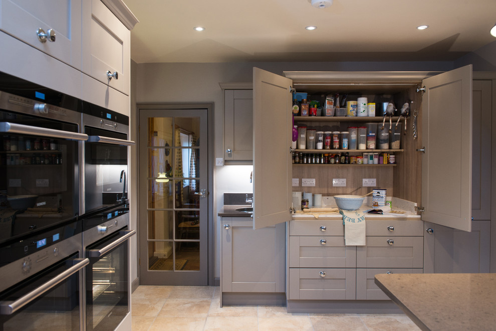 Klassische Küche mit Schrankfronten im Shaker-Stil, grauen Schränken, Küchengeräten aus Edelstahl und Kücheninsel in Surrey