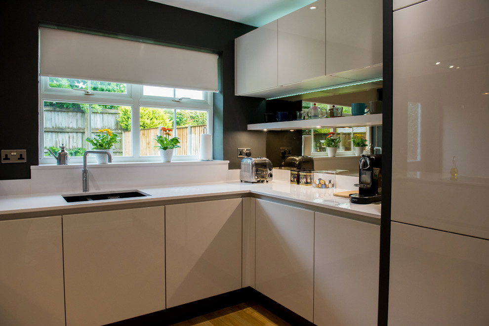 This is an example of a medium sized contemporary kitchen/diner in Other with quartz worktops and no island.