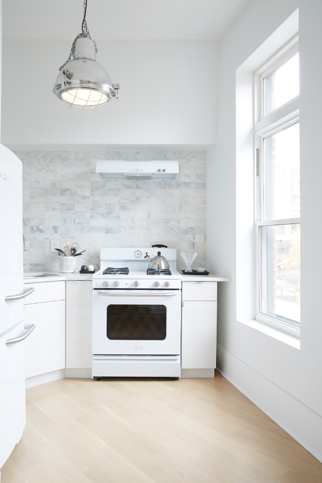 Modelo de cocinas en U actual cerrado sin isla con fregadero encastrado, salpicadero blanco, electrodomésticos blancos y suelo de madera clara