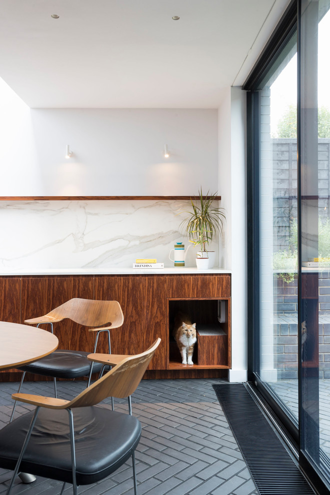 Zweizeilige Moderne Wohnküche ohne Insel mit flächenbündigen Schrankfronten, dunklen Holzschränken, Marmor-Arbeitsplatte, Küchenrückwand in Weiß, Rückwand aus Marmor, Backsteinboden und schwarzem Boden in London
