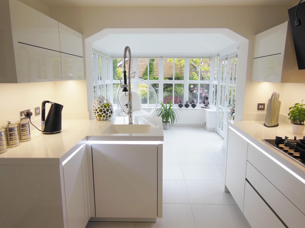 Exempel på ett mellanstort modernt kök, med en enkel diskho, släta luckor, vita skåp, vitt stänkskydd, glaspanel som stänkskydd, rostfria vitvaror, klinkergolv i porslin och en halv köksö