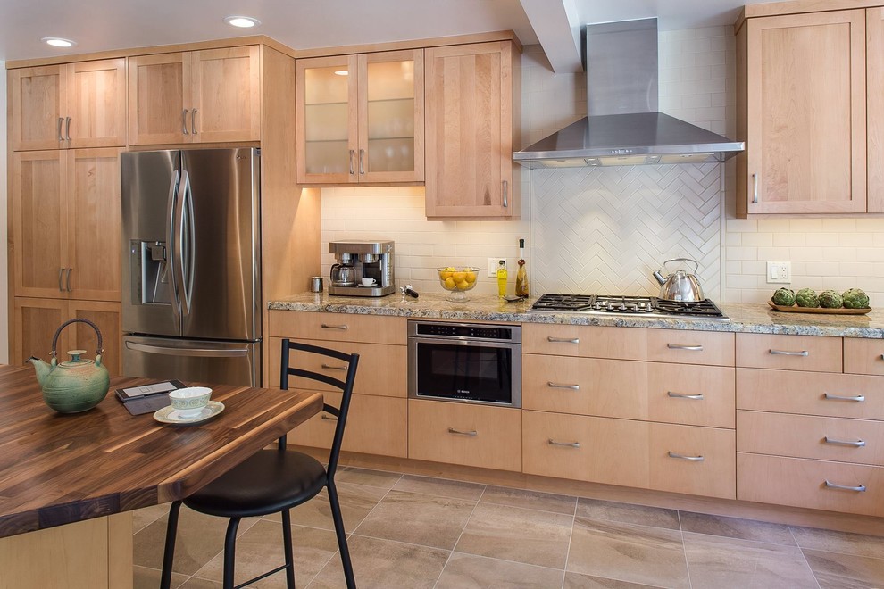 This is an example of a medium sized traditional u-shaped open plan kitchen in San Francisco with a double-bowl sink, shaker cabinets, light wood cabinets, granite worktops, beige splashback, ceramic splashback, stainless steel appliances, ceramic flooring and an island.