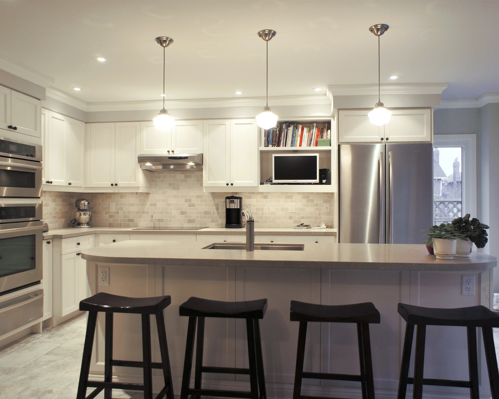 Inspiration for a mid-sized transitional l-shaped porcelain tile eat-in kitchen remodel in Toronto with an undermount sink, white cabinets, quartz countertops, stone tile backsplash, stainless steel appliances, an island, recessed-panel cabinets and gray backsplash