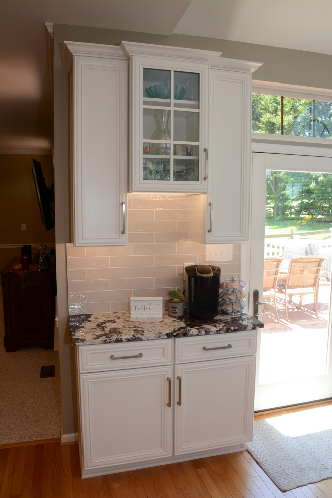 Idéer för att renovera ett mellanstort vintage vit vitt kök, med en undermonterad diskho, luckor med infälld panel, vita skåp, granitbänkskiva, grått stänkskydd, rostfria vitvaror, ljust trägolv, en köksö och brunt golv