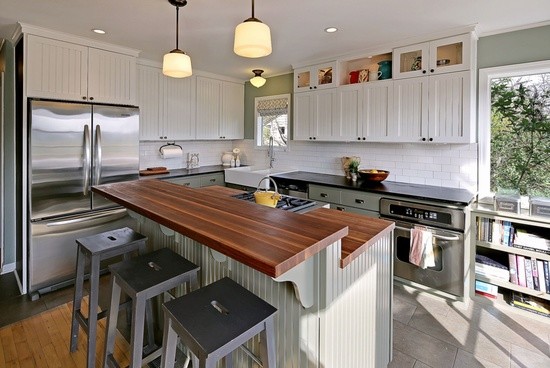 Foto på ett funkis kök med öppen planlösning, med en rustik diskho, skåp i shakerstil, bänkskiva i täljsten, vitt stänkskydd, stänkskydd i keramik, rostfria vitvaror, klinkergolv i keramik och en köksö