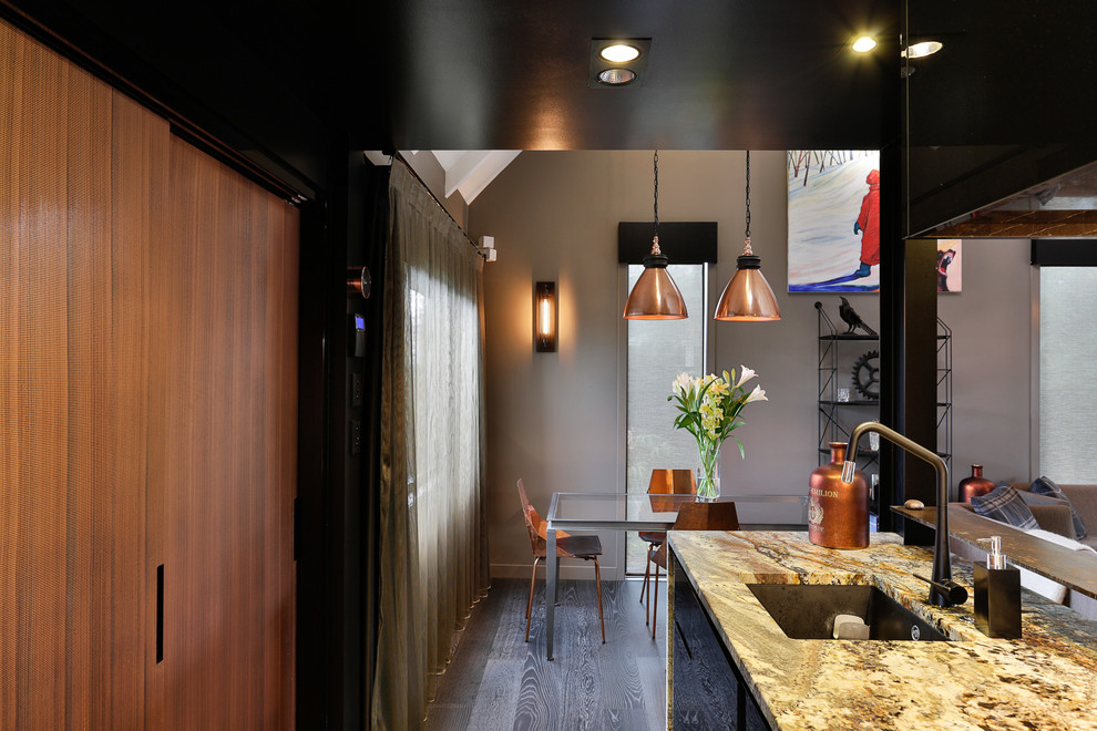 Medium sized urban galley open plan kitchen in Auckland with black cabinets, granite worktops, brown splashback, mosaic tiled splashback, black appliances, dark hardwood flooring, no island and a submerged sink.