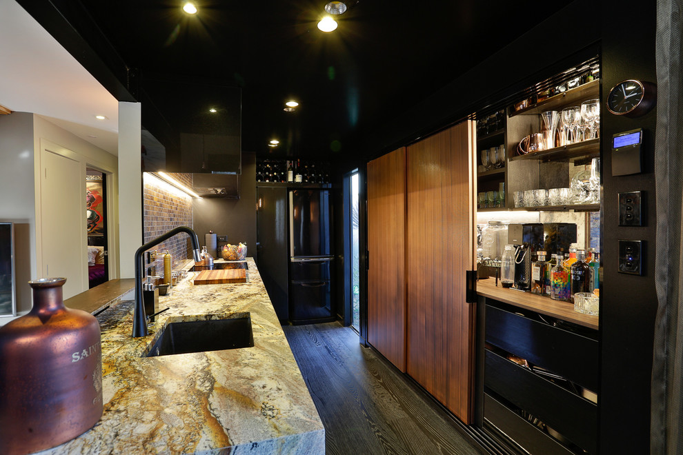 Exempel på ett mellanstort industriellt kök, med en enkel diskho, svarta skåp, granitbänkskiva, brunt stänkskydd, stänkskydd i mosaik, svarta vitvaror och mörkt trägolv