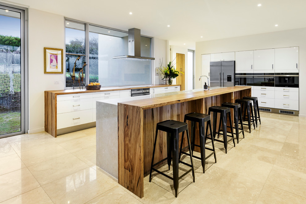 This is an example of a modern kitchen/diner in Melbourne with stainless steel appliances and an island.