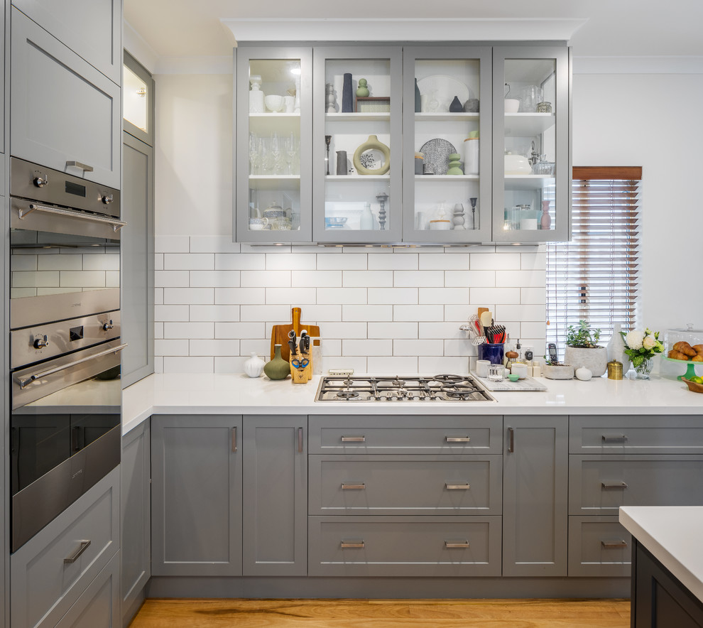 This is an example of a classic kitchen in Perth with shaker cabinets, grey cabinets, engineered stone countertops, white splashback, metro tiled splashback, stainless steel appliances and white worktops.