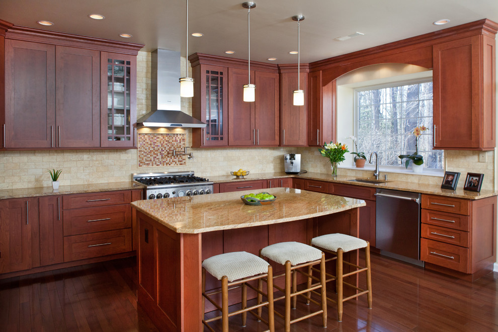 Foto de cocina clásica con armarios estilo shaker, puertas de armario de madera oscura, salpicadero beige, electrodomésticos de acero inoxidable y barras de cocina