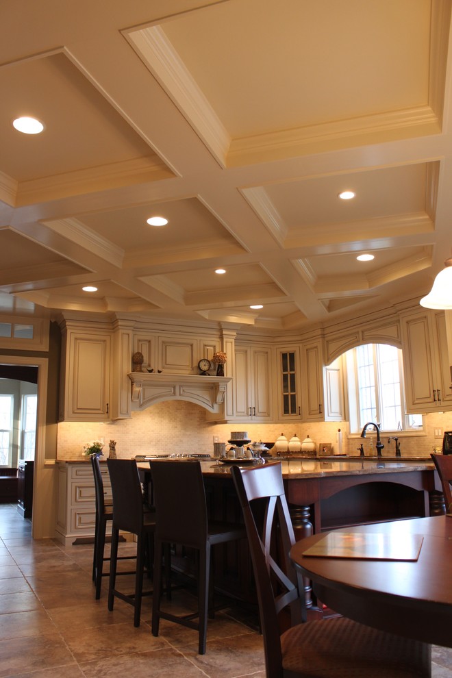 Idéer för ett stort klassiskt kök, med en undermonterad diskho, luckor med upphöjd panel, vita skåp, granitbänkskiva, beige stänkskydd, stänkskydd i stenkakel, rostfria vitvaror, travertin golv och en köksö