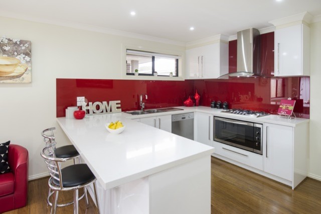 Example of a mid-sized trendy u-shaped bamboo floor kitchen pantry design in Melbourne with a double-bowl sink, recessed-panel cabinets, white cabinets, laminate countertops, red backsplash, glass sheet backsplash, stainless steel appliances and an island