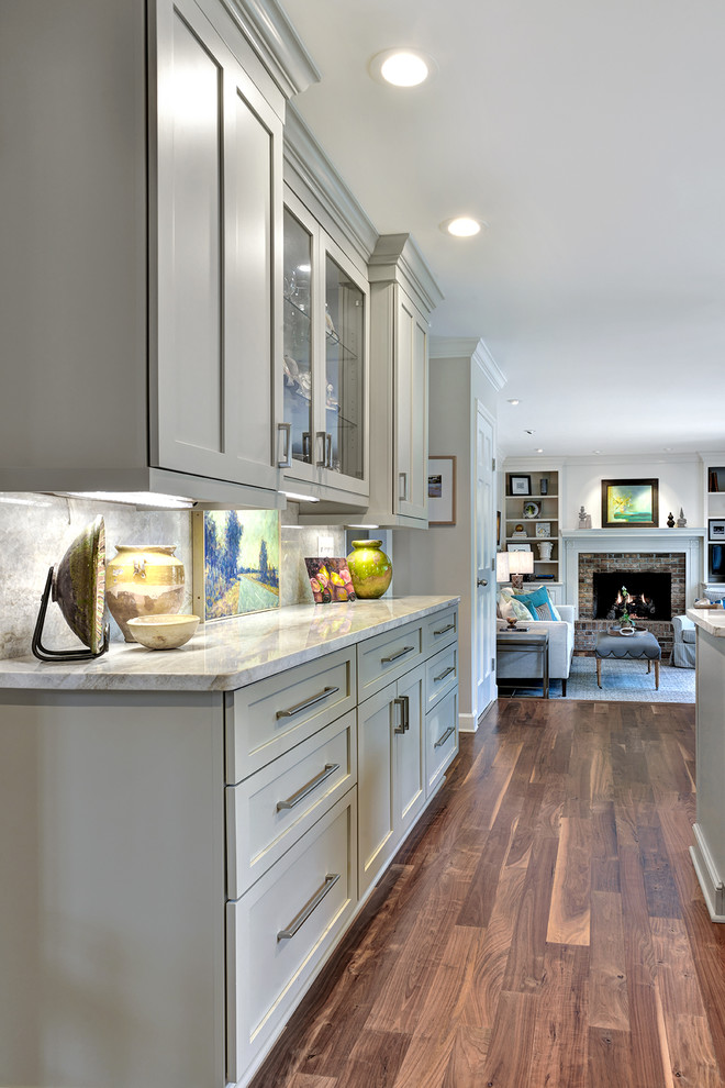 Inspiration for a mid-sized contemporary u-shaped medium tone wood floor open concept kitchen remodel in Charleston with an undermount sink, shaker cabinets, gray cabinets, granite countertops, multicolored backsplash, stone slab backsplash, stainless steel appliances and an island