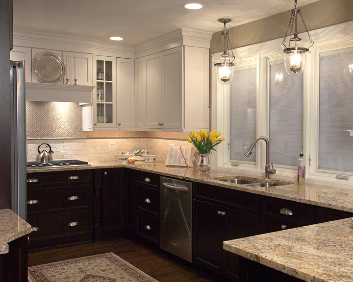 Example of a transitional u-shaped eat-in kitchen design in Chicago with an undermount sink, flat-panel cabinets, granite countertops, beige backsplash, stone tile backsplash and stainless steel appliances