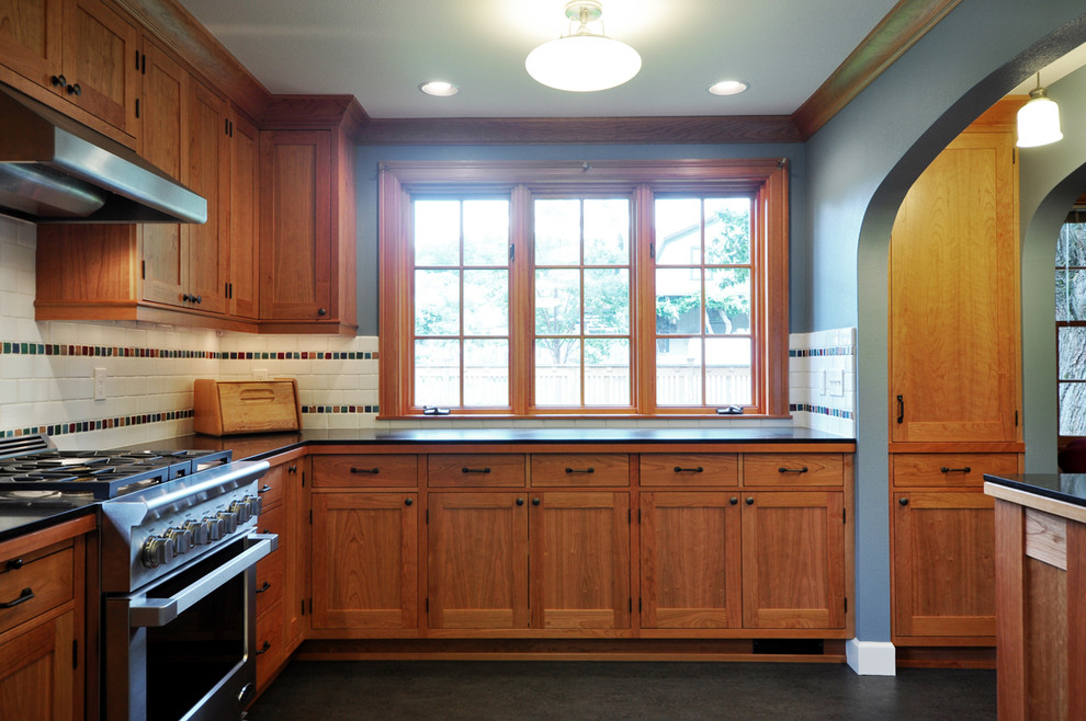 Foto på ett avskilt, stort amerikanskt l-kök, med en enkel diskho, skåp i shakerstil, skåp i mellenmörkt trä, granitbänkskiva, vitt stänkskydd, stänkskydd i keramik, rostfria vitvaror och linoleumgolv