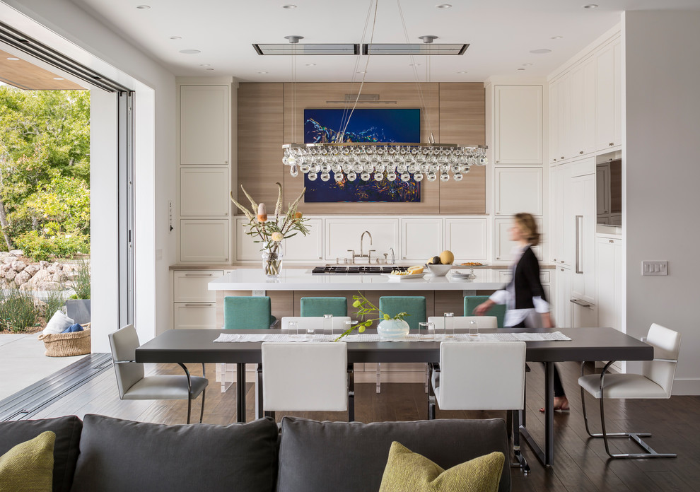 This is an example of a medium sized contemporary open plan kitchen in San Francisco with shaker cabinets, white cabinets, integrated appliances, dark hardwood flooring and an island.