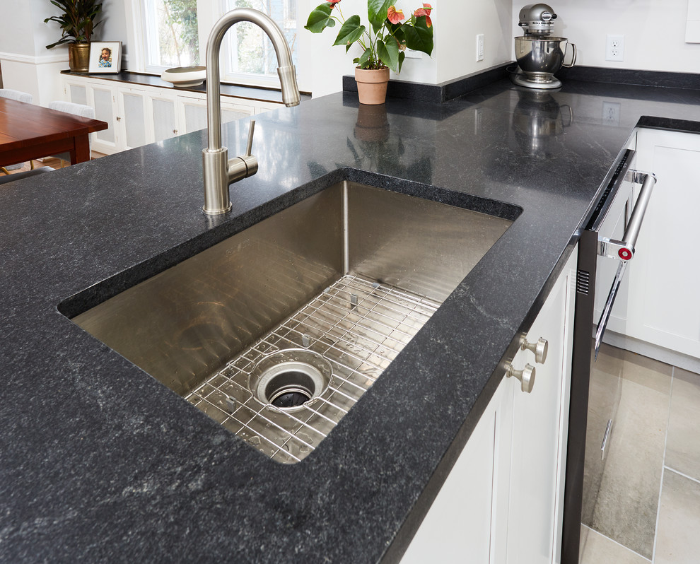 Inspiration for a medium sized classic u-shaped kitchen/diner in Baltimore with a submerged sink, shaker cabinets, white cabinets, granite worktops, white splashback, window splashback, stainless steel appliances, ceramic flooring, a breakfast bar, grey floors and black worktops.