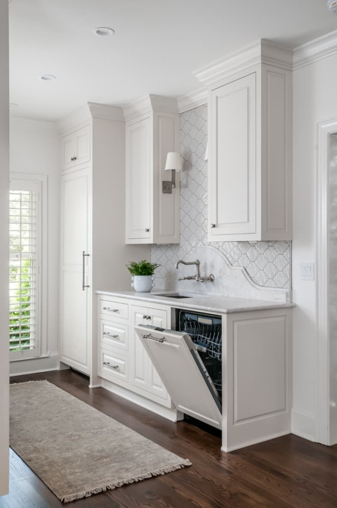 This is an example of a large traditional galley kitchen in Atlanta with a submerged sink, shaker cabinets, white cabinets, quartz worktops, beige splashback, integrated appliances, medium hardwood flooring, brown floors and white worktops.