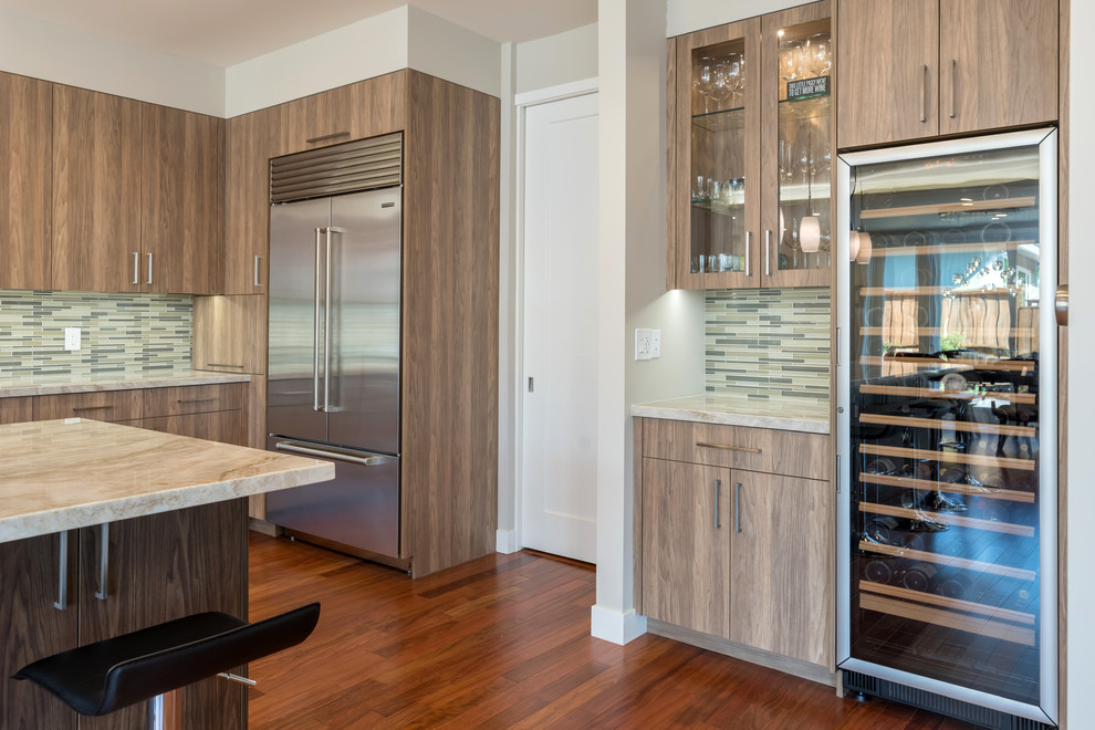 Photo of a contemporary kitchen in San Francisco with a belfast sink, flat-panel cabinets, medium wood cabinets, multi-coloured splashback, glass tiled splashback, stainless steel appliances, light hardwood flooring, an island and brown floors.